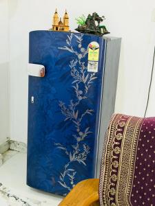 a blue refrigerator sitting next to a chair at Sadhana kunj in Varanasi