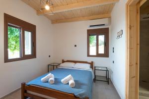 a bedroom with a bed with two towels on it at Mulberry Tree House in Póndi