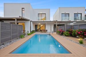a house with a swimming pool in front of it at Saronia Estate in Galatákion