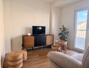 ein Wohnzimmer mit Fernseher, Sofa und Sesseln in der Unterkunft O Abeiro in Corcubión