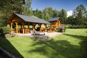 a wooden pavilion with a picnic table in a park at Chata Vanilka in Bělá pod Pradědem