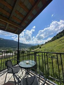 a table and chairs on a balcony with a view at Ivlita in Mestia