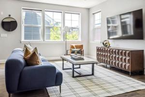 a living room with a blue couch and a coffee table at Modern Elegance - Pool Table - Walkable Area in Aurora