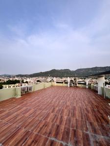 a roof top with a wooden floor and mountains in the background at Hotel Golden Heights in Ajmer +17 photos