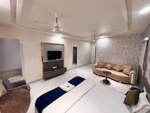 a living room with a large bed and a couch at Hotel Golden Heights in Ajmer