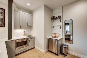 a kitchen with stainless steel appliances and a mirror at Modern ADA-Accessible Studio - Tennyson St Escape in Denver
