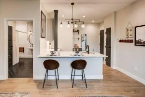 a kitchen with a sink and two bar stools at Modern ADA-Accessible Studio - Tennyson St Escape in Denver +11 photos
