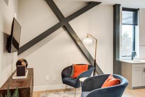 a living room with two chairs and a tv at Walkable Urban Tennyson St Apt - Steps to Eats in Denver