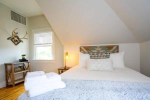a bedroom with a bed with white sheets and a window at Pinky's Palace - Curtis Park Club - RiNo in Denver