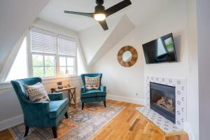 a living room with two chairs and a fireplace at Pinky's Palace - Curtis Park Club - RiNo in Denver