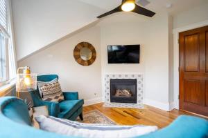 a living room with a ceiling fan and a fireplace at Pinky's Palace - Curtis Park Club - RiNo in Denver +13 photos