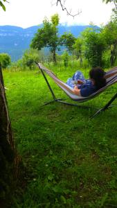 two people laying in a hammock in a field at olya's garden in Tsʼageri