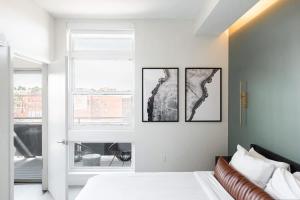 a bedroom with a bed and three pictures on the wall at New Spacious Modern Loft - Center of LoHi in Denver