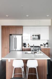 a kitchen with a large white island with two stools at New Spacious Modern Loft - Center of LoHi in Denver