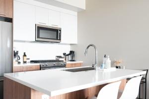 a kitchen with white cabinets and a white counter top at New Spacious Modern Loft - Center of LoHi in Denver