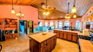 a large kitchen with orange walls and wooden ceilings at El Palacio Rosa, The Resort in Punta Gorda