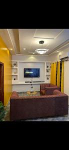 a living room with a couch and a flat screen tv at Empereur City in Ouidah