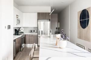 a white kitchen with a large white counter top at Contemporary Condo - Grill - Balcony - Tesoro in Denver
