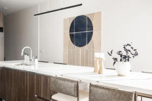 a kitchen with a sink and a counter with chairs at Contemporary Condo - Grill - Balcony - Tesoro in Denver