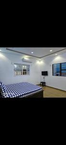 a white room with a bed and a television at Empereur City in Ouidah