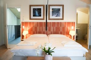 a bedroom with two beds and two pictures on the wall at Locanda del Persico in Morbio Inferiore