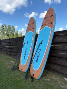 two surfboards sitting on top of a fence at Rātes Krasti - Rasa - holiday house with sauna and lakeview in Lejasciems