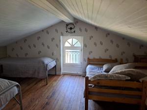 a attic room with two beds and a window at Halte à Ecluse d'Hôte in Calonges