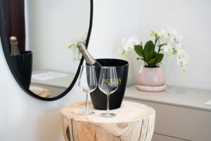 a table with two wine glasses and a mirror at Locanda del Persico in Morbio Inferiore
