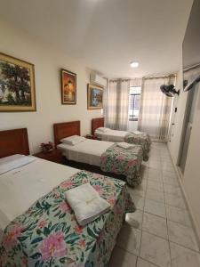 a hotel room with three beds in a room at ISIS HOTEl in Tumbes