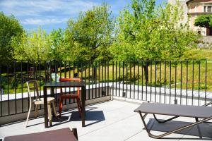 a patio with a table and chairs and a fence at Locanda del Persico in Morbio Inferiore