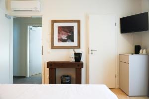 a bedroom with a bed and a table and a tv at Locanda del Persico in Morbio Inferiore