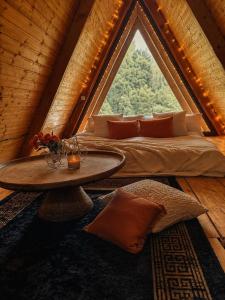 a room with a bed and a table in front of a window at cottage sunrise house merisi in Merisi