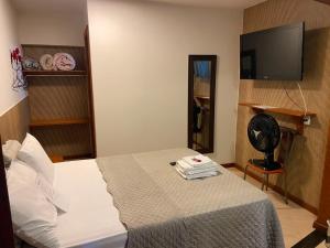 a bedroom with a bed and a flat screen tv at Estalagem O Italiano in Lumiar