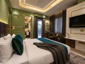 a hotel room with a bed and a flat screen tv at Hotel Central Park Inn, in Dehradun