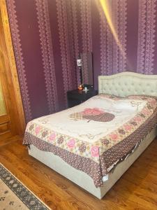 a bed in a room with a purple wall at Kakuti village in Natskhavatevi