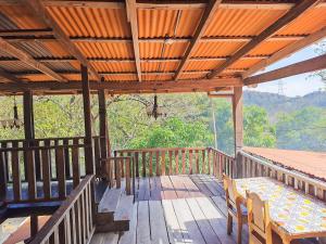 a wooden deck with a table and chairs on it at Parque Indigo Nature Lodge, Rincón de la Vieja in Liberia