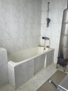 a white bath tub in a white tiled bathroom at Kakuti village in Natskhavatevi +19 photos