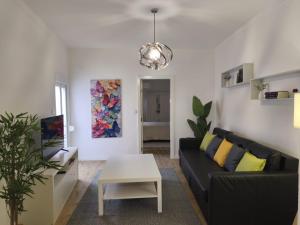 a living room with a black couch and a table at Flor de Charme in Campo Maior
