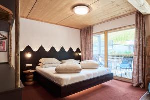 a bedroom with a large bed and a balcony at Apart Marienberg in Lermoos