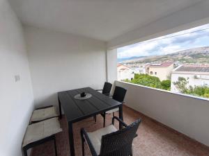 a dining room with a table and chairs and a large window at Apartments Šešo A in Pag