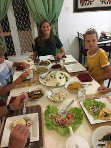 a group of people sitting around a table with food at Cloud Inn Kandy Homestay - Near temple tooth in Kandy +24 photos