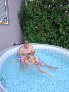 a man and a child in a swimming pool at Kucerak u Sremu in Klenak
