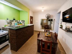 a kitchen with a table and a kitchen with green walls at Alojamiento Marlugm in Corrientes