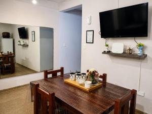 a dining room table with a television on a wall at Alojamiento Marlugm in Corrientes
