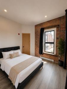 a bedroom with a large bed and a brick wall at The Post Hotel in Renfrew