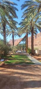 a building with palm trees in a park at كوخ ساره سبيشل دورين in Al-ʿUla