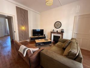 a living room with a couch and a fireplace at F4 Cosy Centre Moulins - 3 chambres lits doubles -idéal Famille & Séjour Pro in Moulins