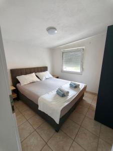 a bedroom with a bed with two towels on it at Apartments Šešo A in Pag