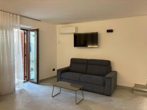 a living room with a couch and a tv at Relax nel Centro Storico in San Nicola Arcella