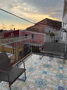 a balcony with chairs and a tile floor on a building at Relax nel Centro Storico in San Nicola Arcella